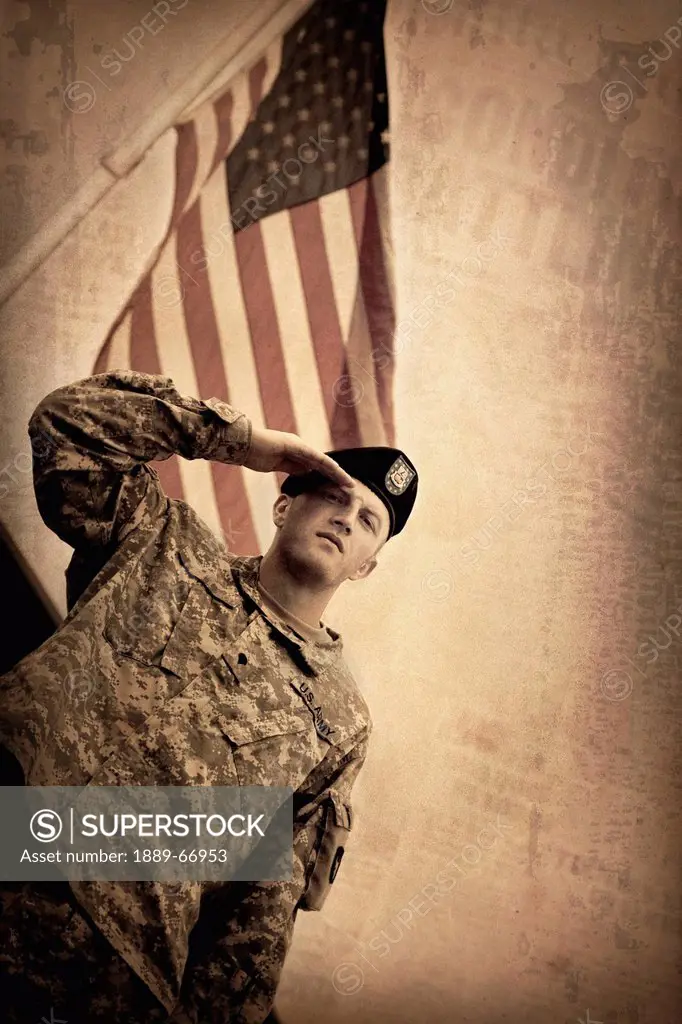 army soldier saluting with flag in background