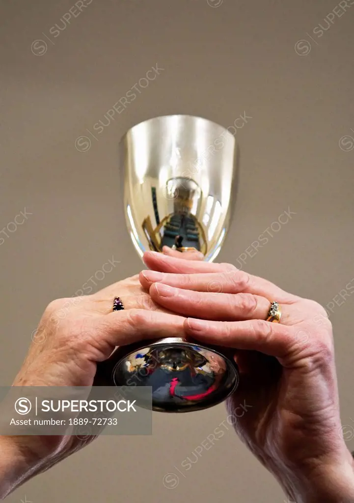 hands holding up a communion goblet, sheffield south yorkshire england