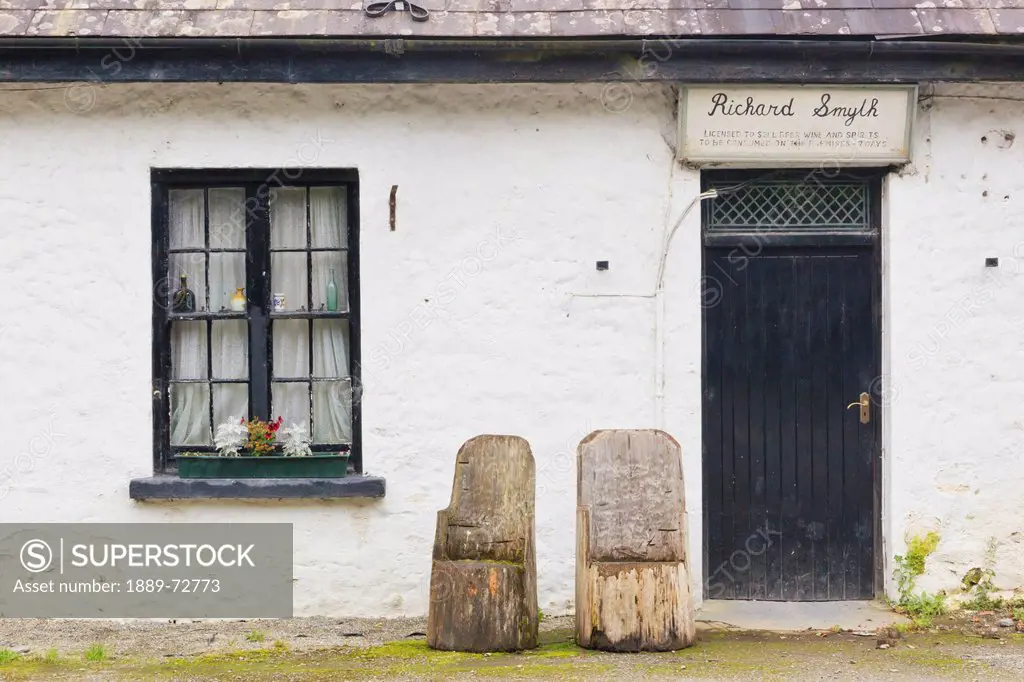 front of richard smyth´s pub with chairs hand carved from trunks of wood in the healy pass, county kerry republic of ireland
