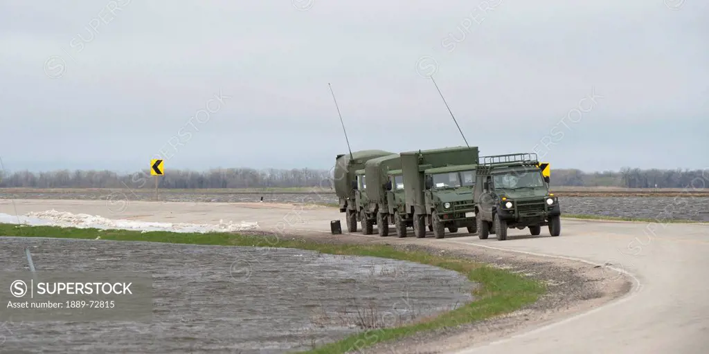 army trucks arrive to provide aid to a flooded area, st. francois xavier manitoba canada