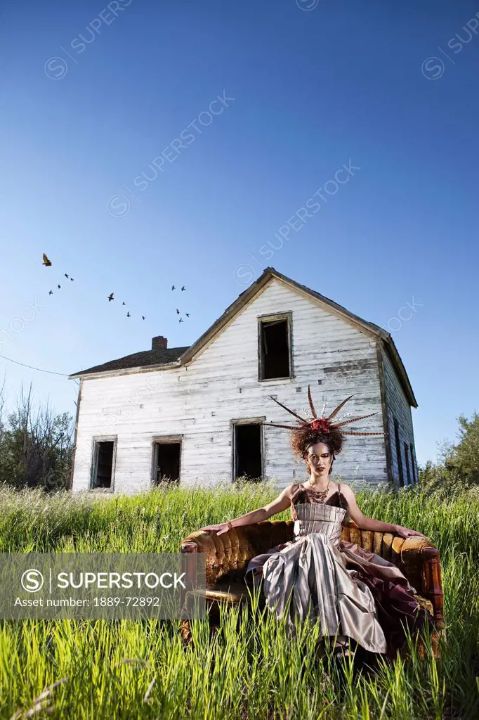 sitting in glamorous outfit with an abandoned house in the background, edmonton alberta canada