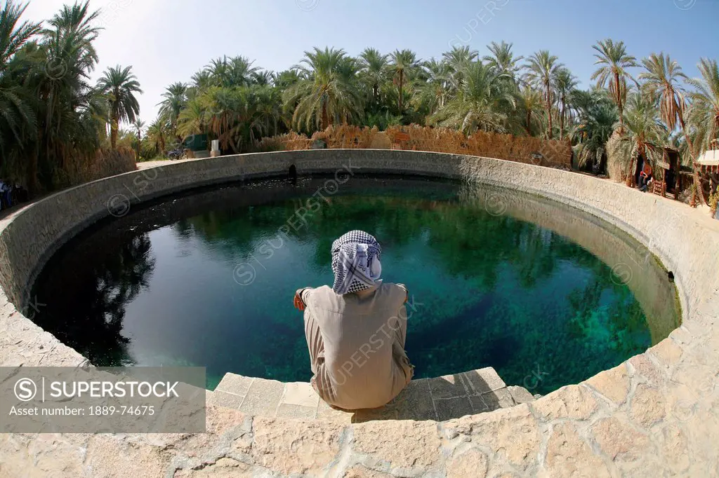 A Local Siwan Man Looks Into Cleopatra´s Pool A Natural Fresh Water Spring In Siwa At The Siwa Oasis, Siwa Egypt