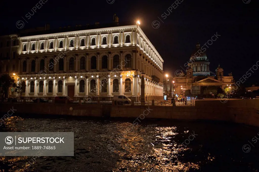 A building illuminated at night on the edge of moyka river, st. petersburg russia