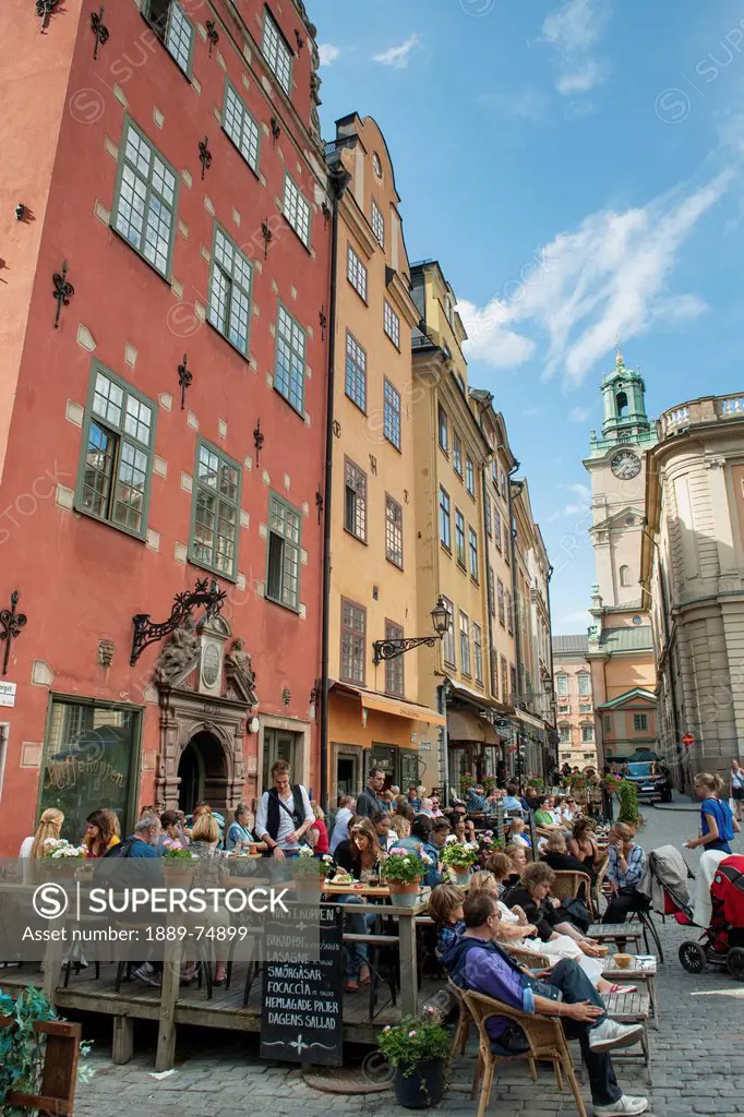 Large group of people seated on an outdoor patio in old town, stockholm sweden