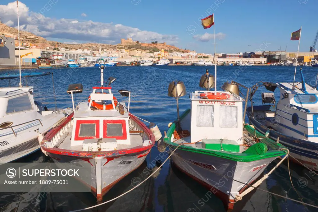 Fishing boats in the harbour and the moorish alcazaba or castle in background, almeria almeria province spain