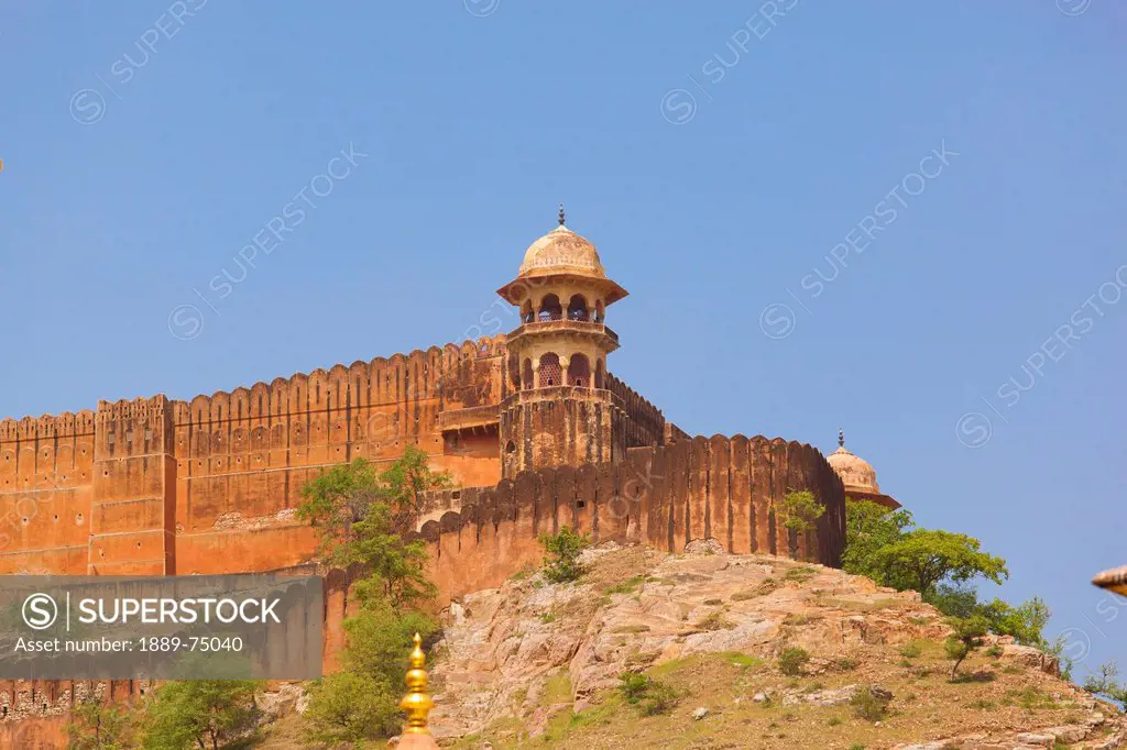 A tower and wall at the corner of amer fort against a blue sky, jaipur rajasthan india