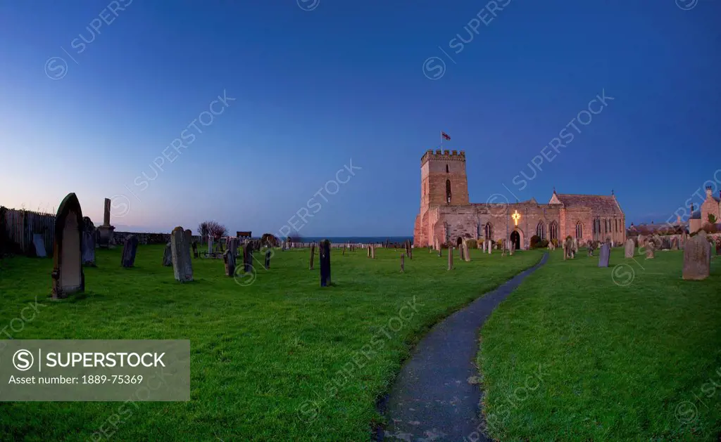 A Path Leading Through A Cemetery To A Church Building, Bamburgh Northumberland England