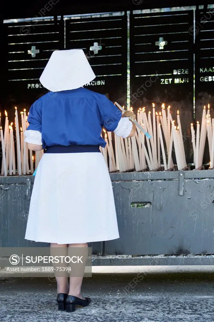 Nun Lighting A Blessed Candle Sanctuary Of Our Lady Of Lourdes, Lourdes Hautes_Pyrenees France