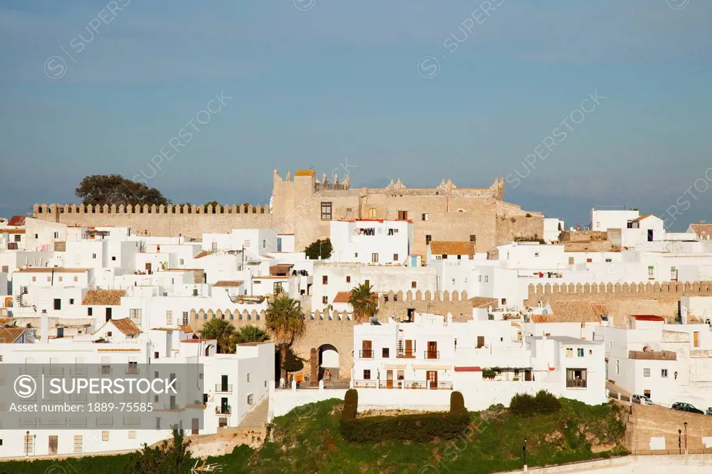 Cityscape of white and brown buildings against a blue sky, vejer de la frontera andalusia spain