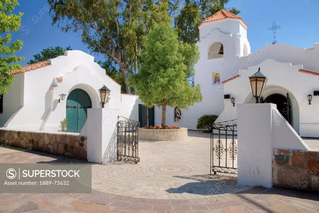 Church with a whitewashed building and stone fence, chacras de coria mendoza argentina