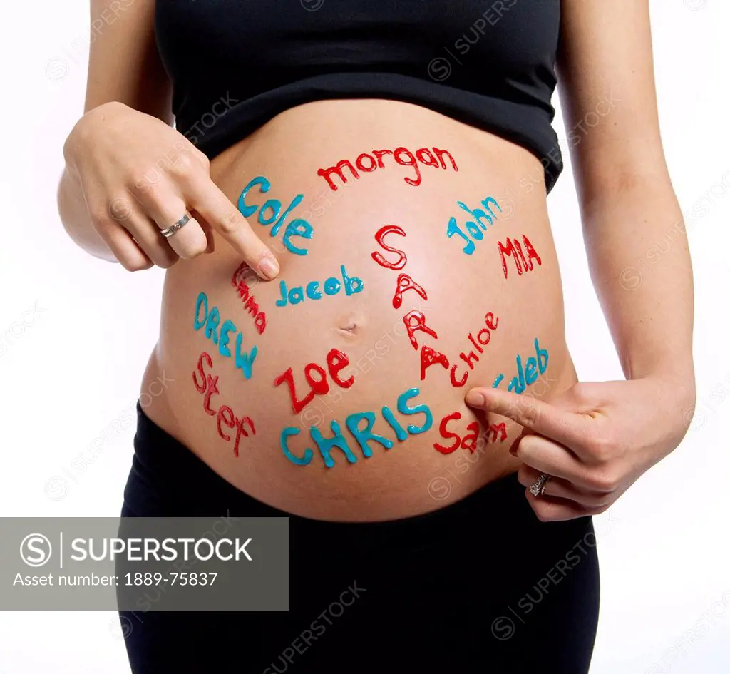 A woman´s pregnant belly with boy and girl names written all over it, edmonton alberta canada