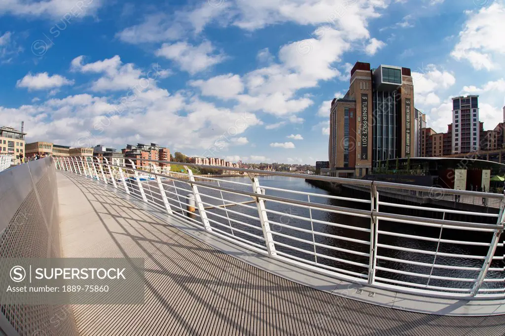 A Pedestrian Bridge Across River Tyne With Buildings Along The Waterfront, Newcastle Northumberland England