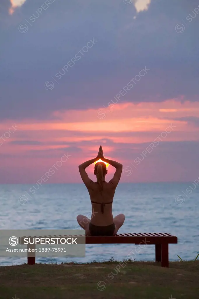 A Woman Tourist Does Yoga And Stretching At Sunset On The Beach Of A Tropical Island, Koh Lanta Thailand