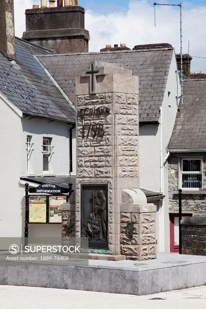 A stone monument with a cross and a visitor information sign, castlebar county mayo ireland