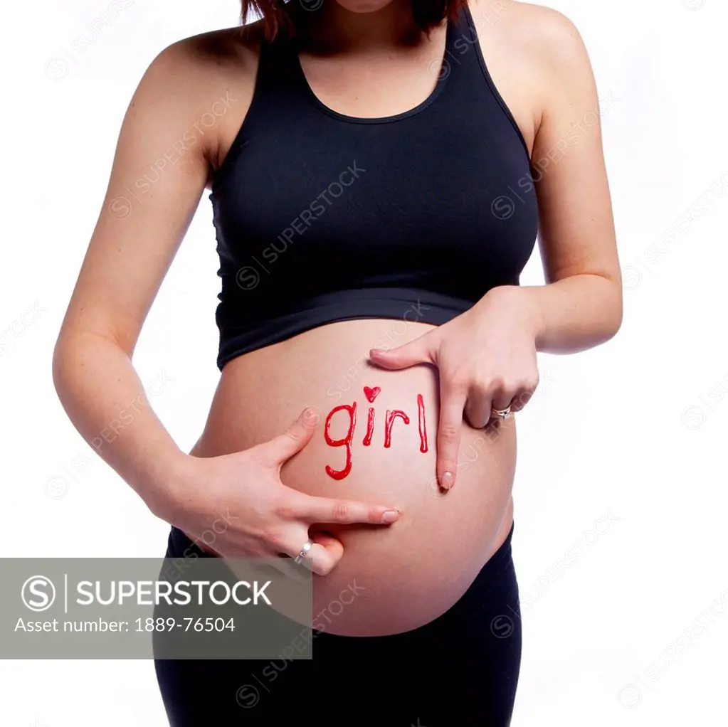 A woman´s pregnant belly with the word girl written on it, edmonton alberta canada