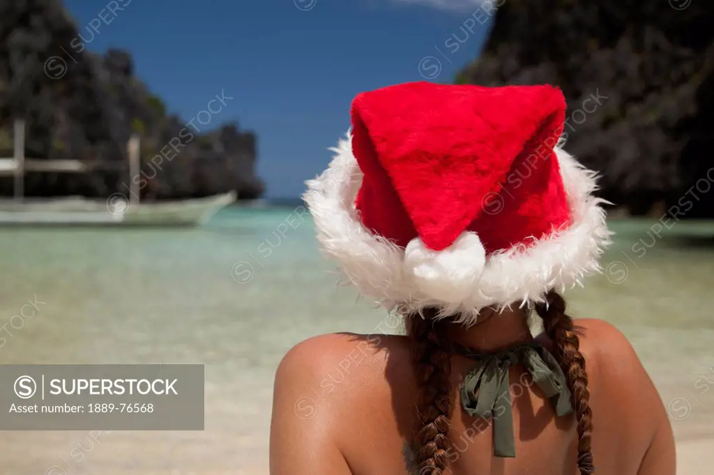 A Woman Tourist Wears A Santa Hat And Bikini On Tropical Matinloc Island Near El Nido And Corong Corong, Bacuit Archipelago On Palawan Philippines