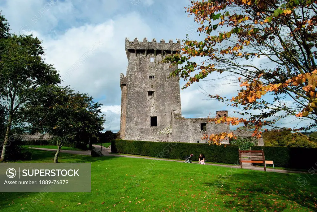 A Parent And Child On The Grass In Front Of An Historic Stone Building, Blarney County Cork Ireland