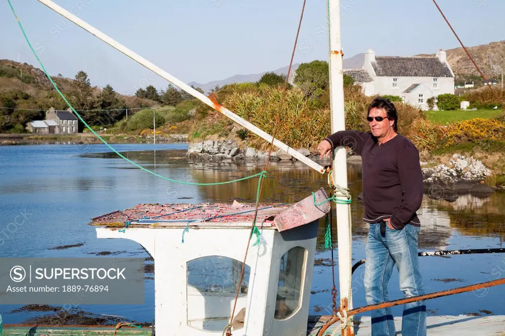 A Man Stands On An Old Fishing Boat Near Eyeries, County Cork Ireland