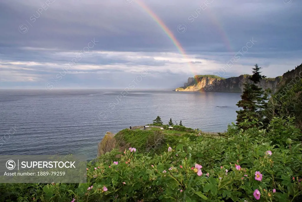 double rainbow on a seaside cliff, quebec canada