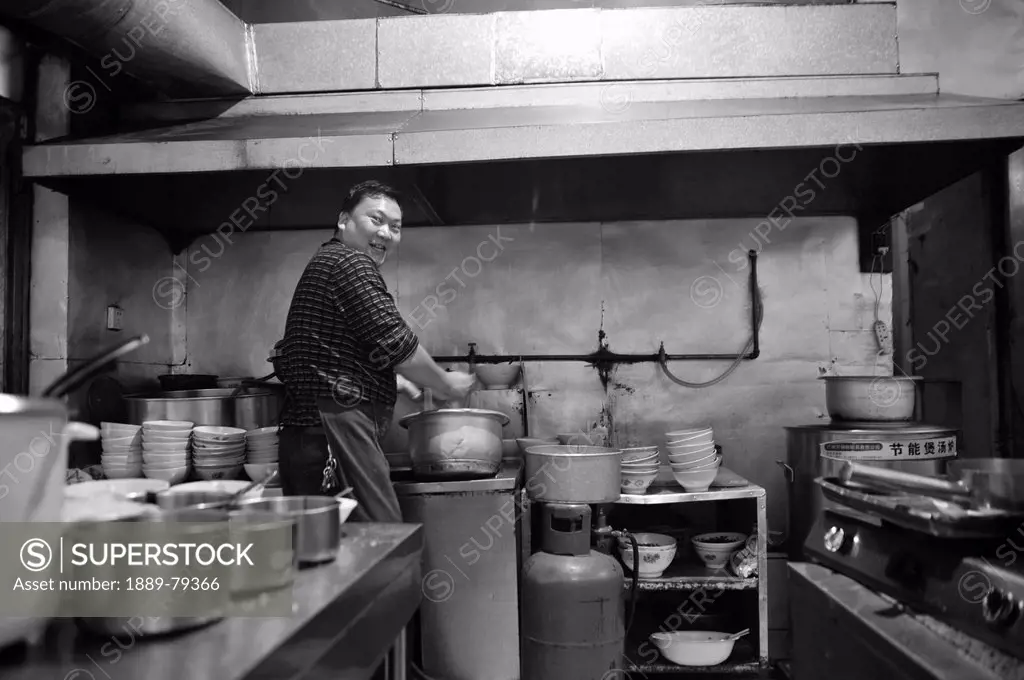 a man working in a kitchen, ruili yunnan china