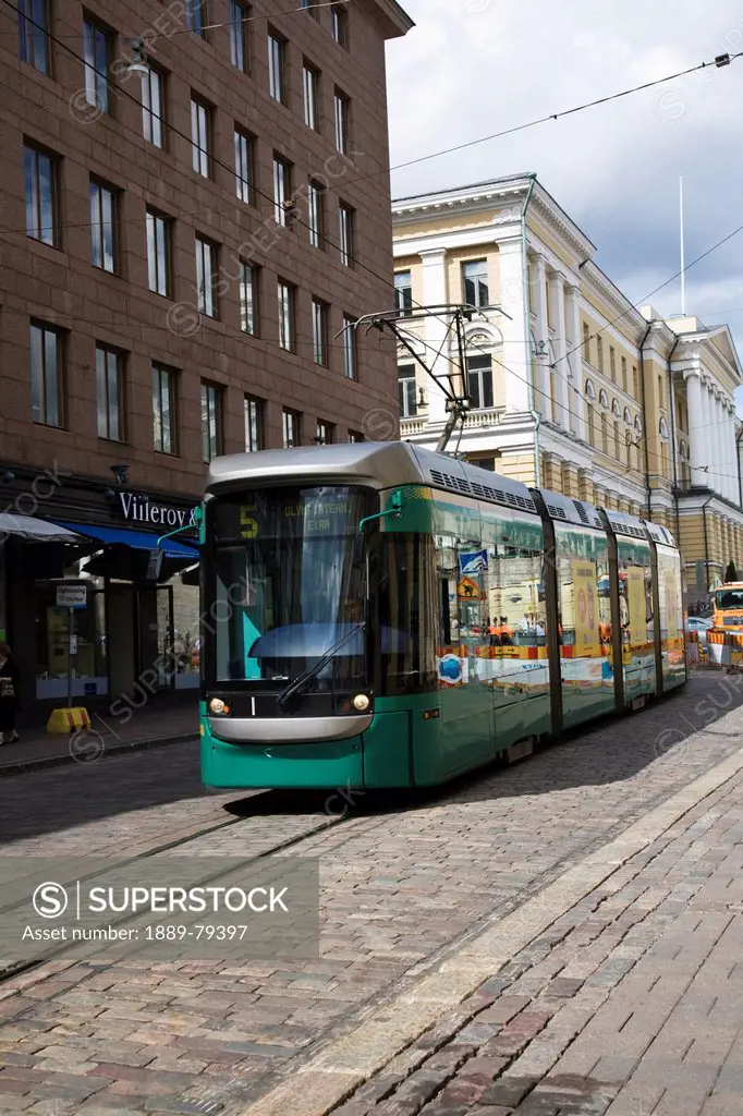 tramway traveling by buildings, helsinki, finland