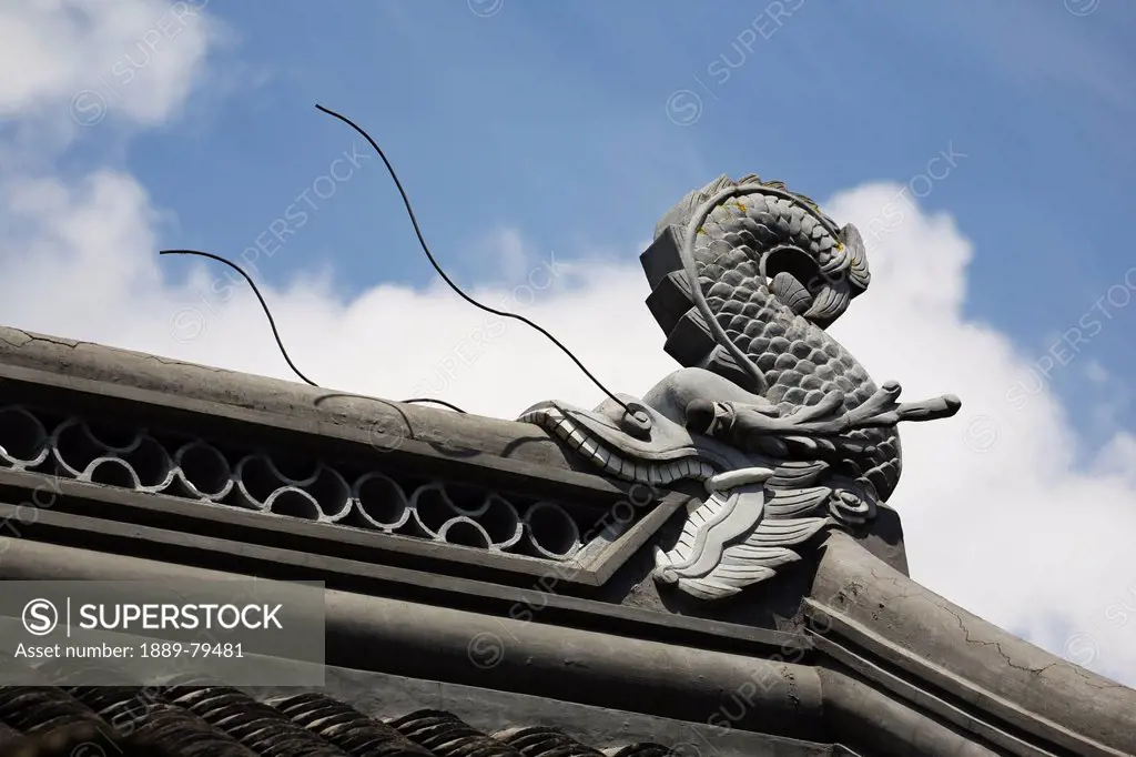 sculpture of a dragonfish eating the roof of a building, portland oregon united states of america