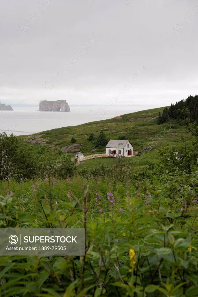 historic house on bonaventure island with rocher_perc in the distance, perce quebec canada