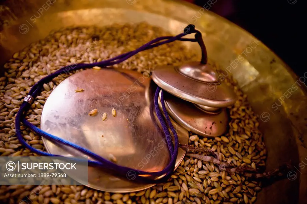 Circular Bronze Items In A Bowl Full Of Grains Of Rice, Leh Ladakh India