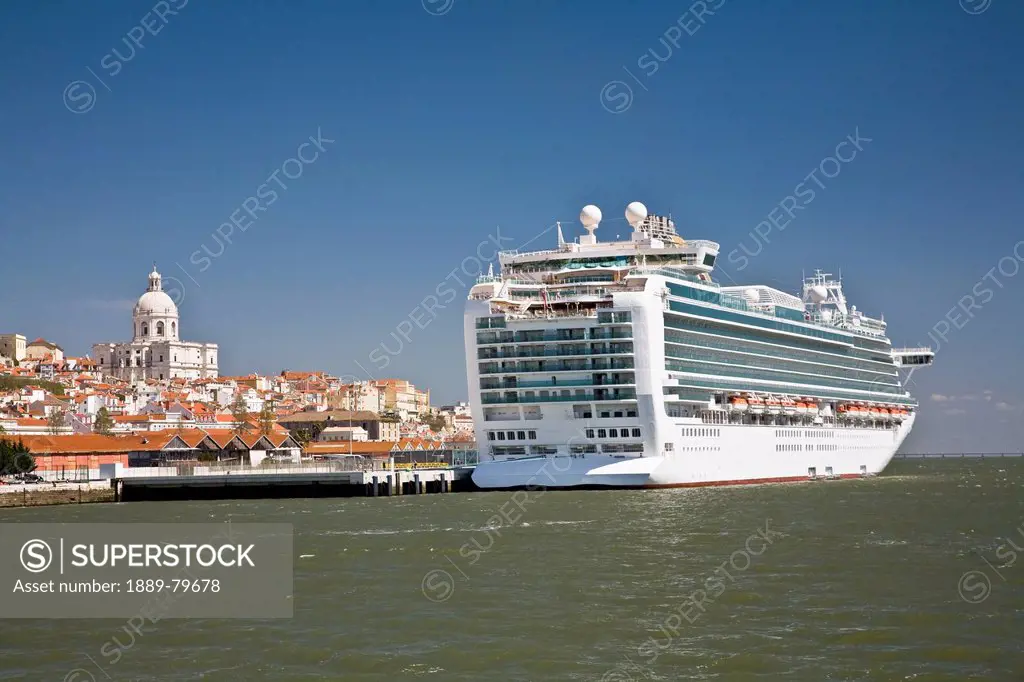 a cruise ship moored with the church of santa engracia in the background, lisbon, portugal