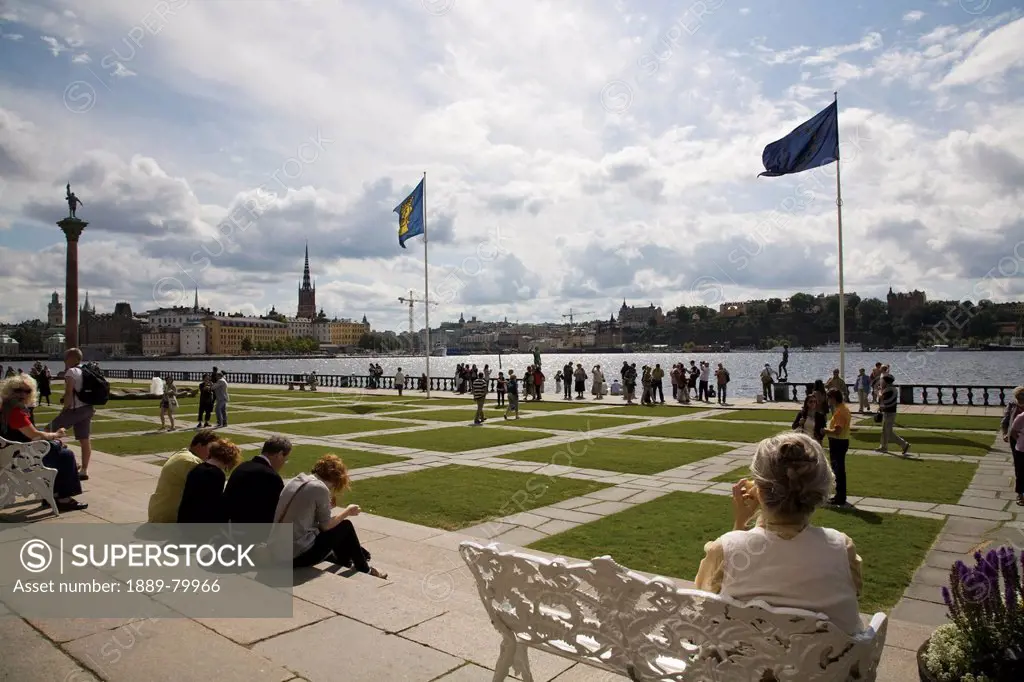 tourists in the city hall gardens on lake malaren, stockholm, sweden