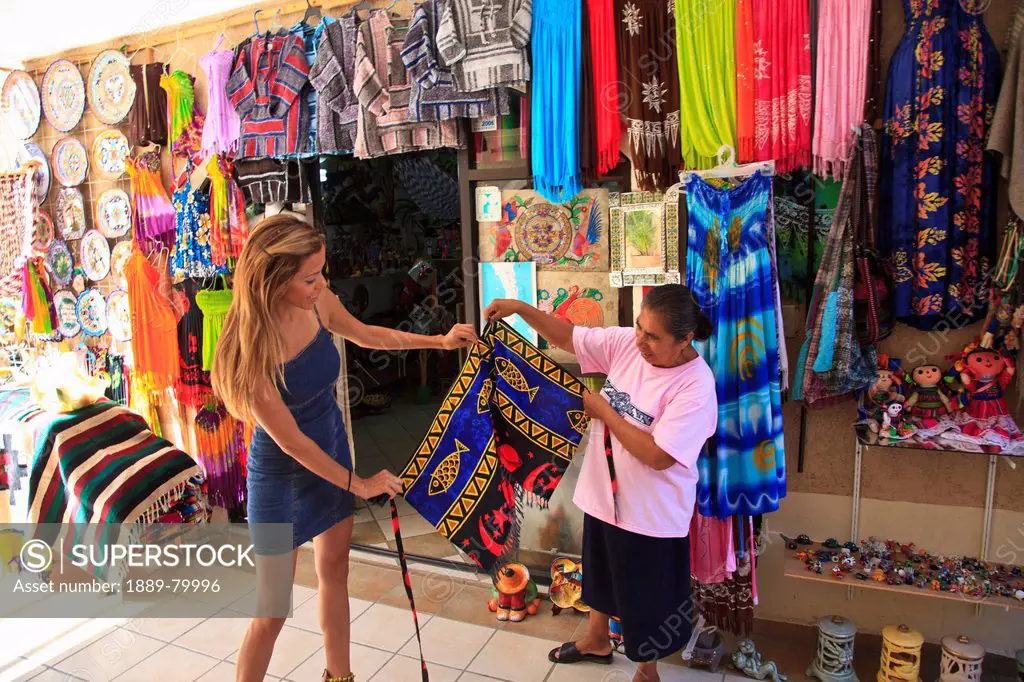 women downtown looking at textiles on display, todos santos baja california sur mexico