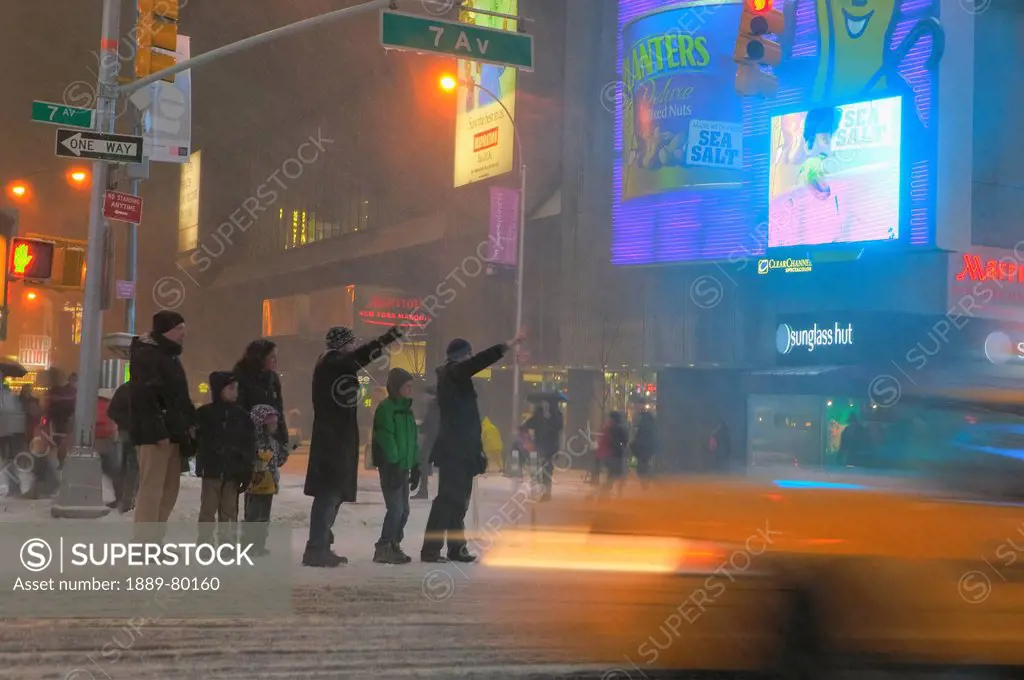 hailing a cab during winter storm in times square, new york city, new york, united states of america