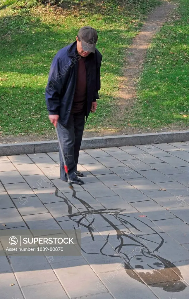 A man draws a picture of a woman on a stone path, beijing china