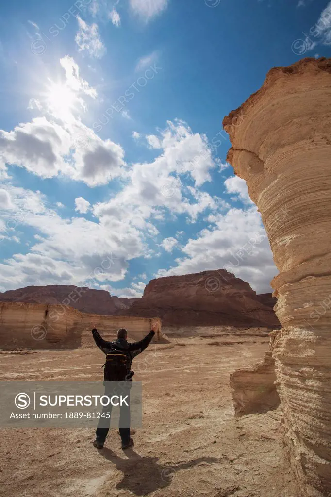 A man with arms raised at masada a place of ancient fortifications, masada southern district israel