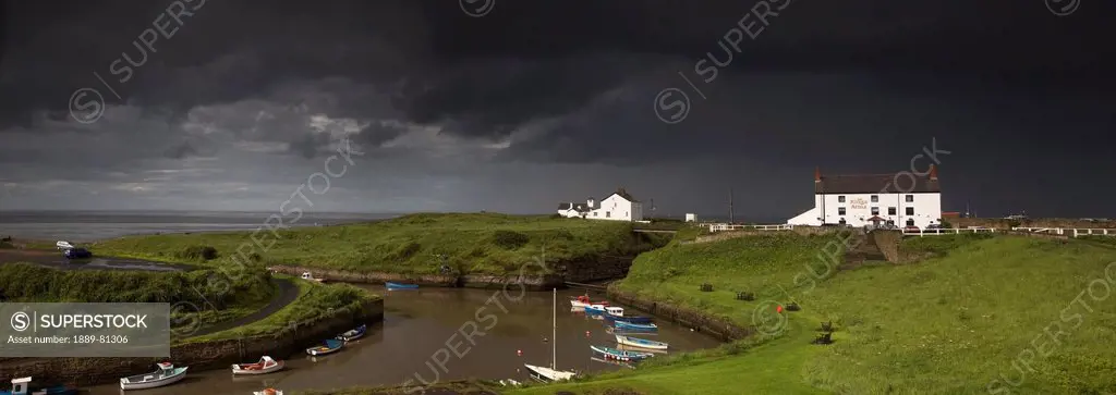 Dark storm clouds over a village on the coast, seaton sluice northumberland england