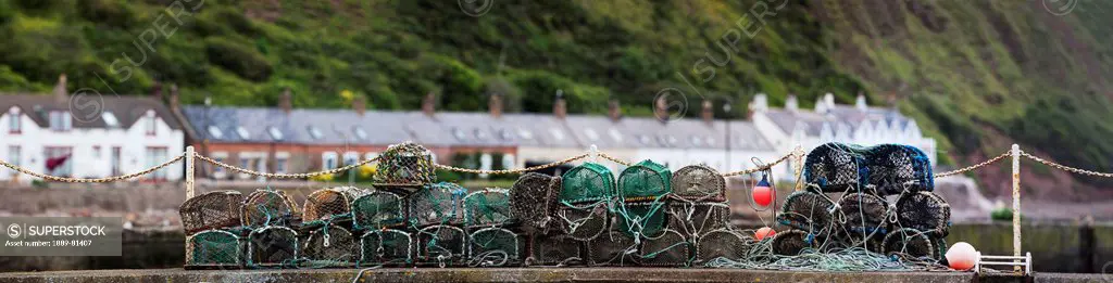 Traps piled on the shore with houses in the background, burnmouth scottish borders scotland