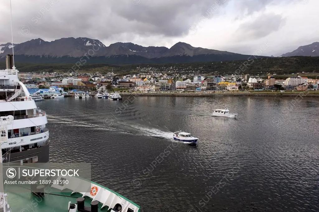 Boats in the water and cityscape with mountains in the distance, ushuaia argentina