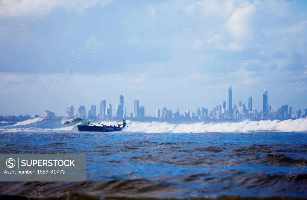 Rowing a boat in a large wave at surfer´s paradise, gold coast queensland australia