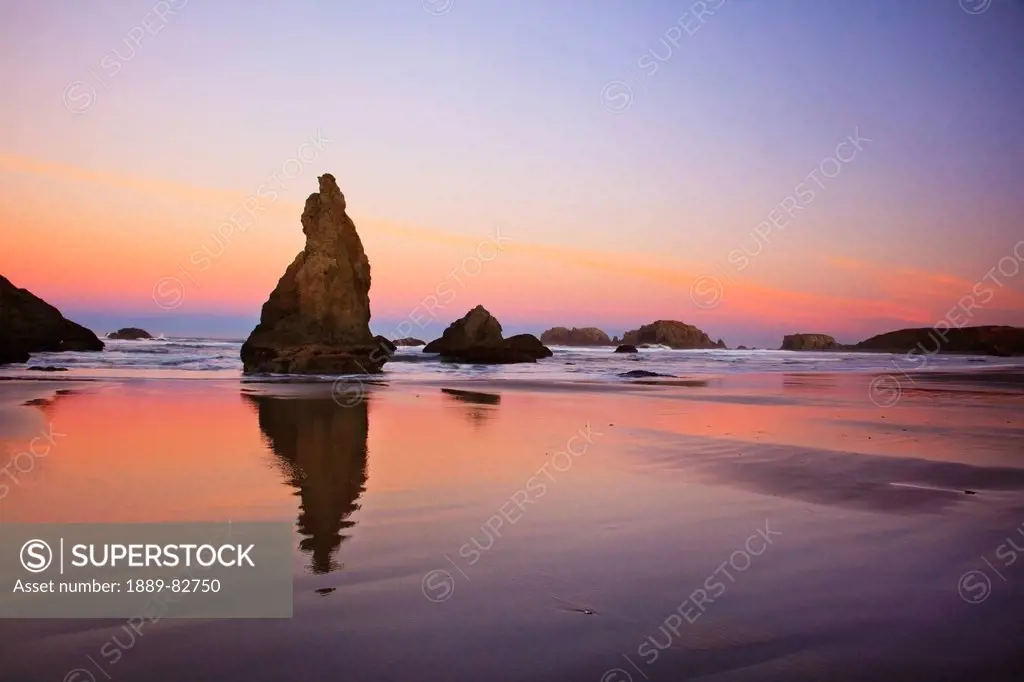 Sunset over rock formations reflecting in tide pools at low tide, bandon beach, oregon, united states of america