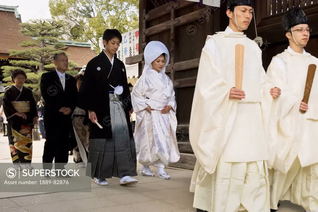 Traditional japanese wedding walking through the temple gate, kyoto, japan
