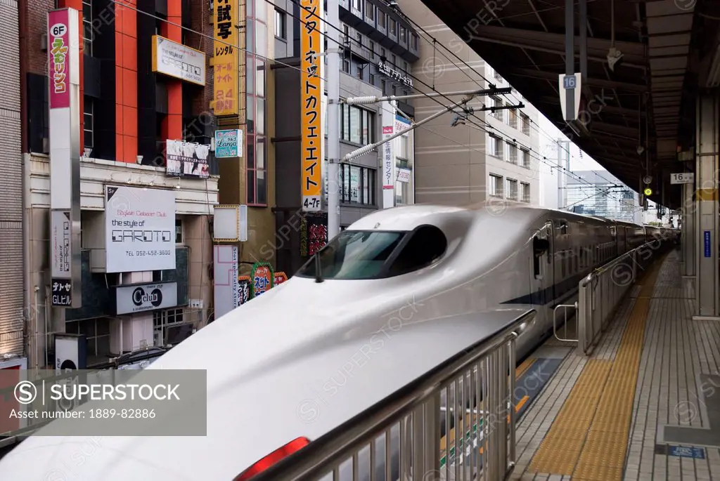 Japanese high speed train waiting at the station with buildings close behind, tokyo, japan