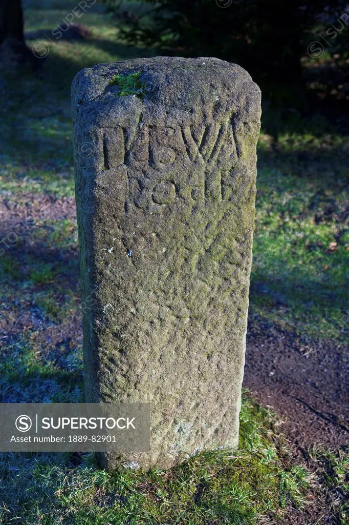 An old stone marker with worn inscription, derbyshire, england