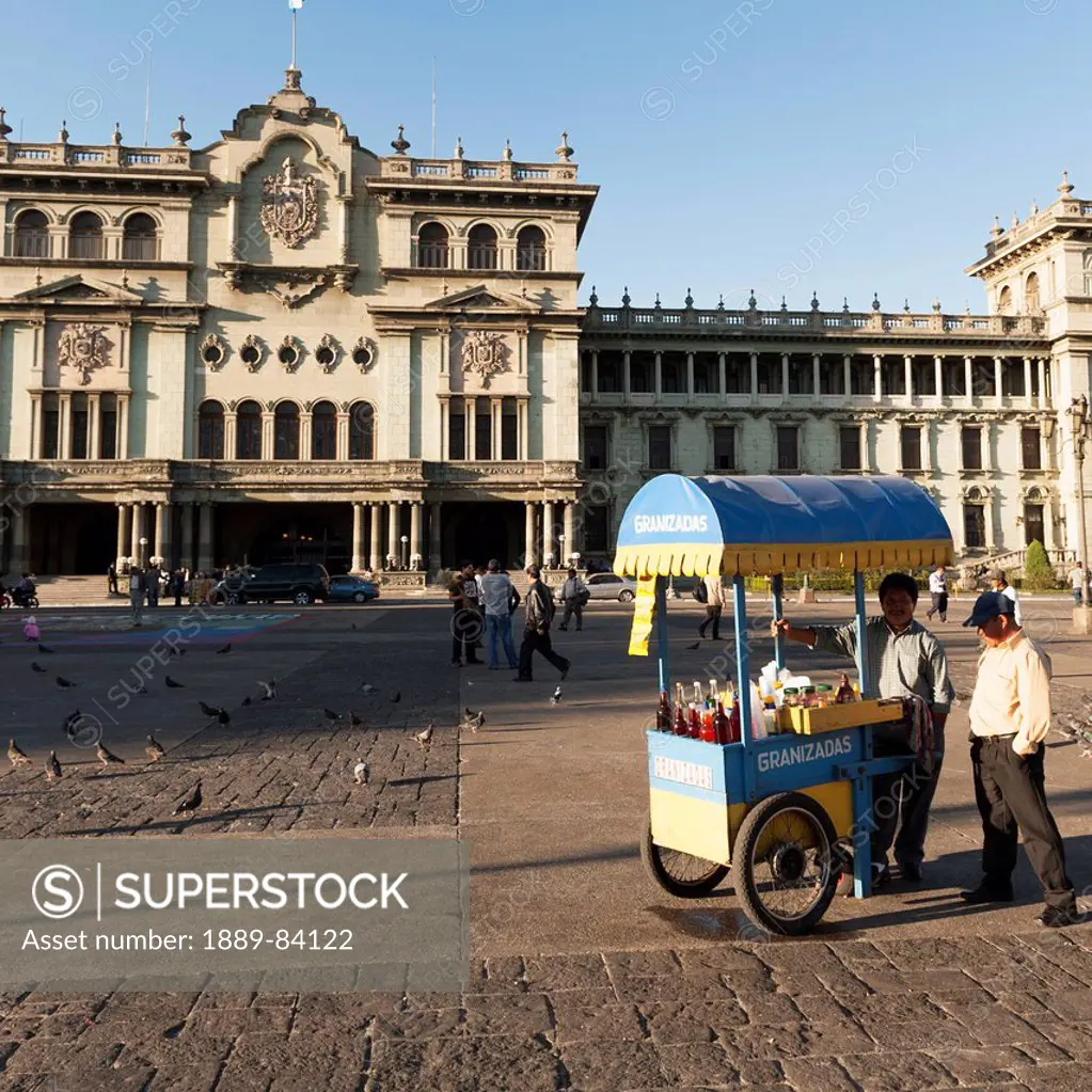 Two Men Selling Beverages At A Cart In A Town Square, Guatemala City Guatemala
