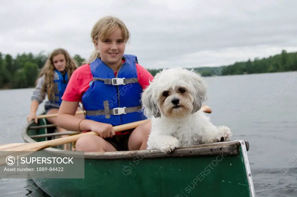 Two Girls In A Canoe With Their Pet Dog, Lake Of The Woods Ontario Canada