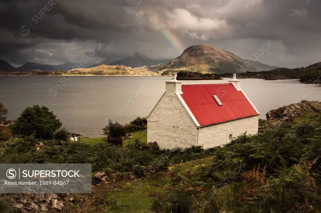 A Cottage With A Red Roof On The Water´s Edge With A Rainbow In The Distance, Applecross Peninsula Highlands Scotland