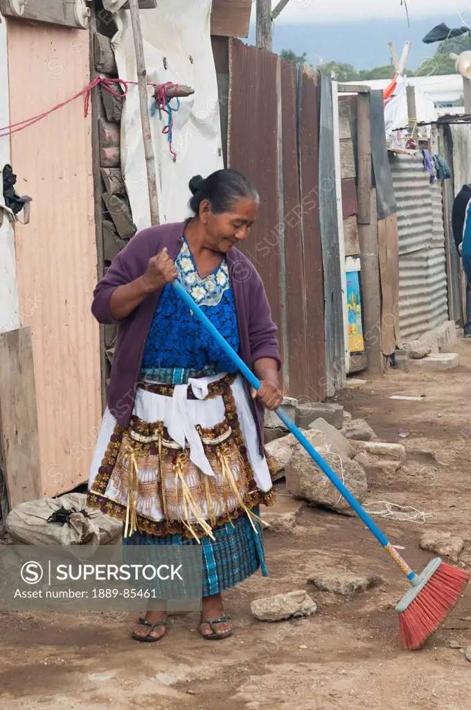 A Woman Sweeps In The Street In Front Of Her House, Guatemala City Guatemala