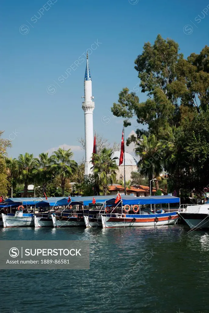 Turkey, Western Mediteranean, Tourist Boats Along Shore In Front Of Minaret; Dalyan