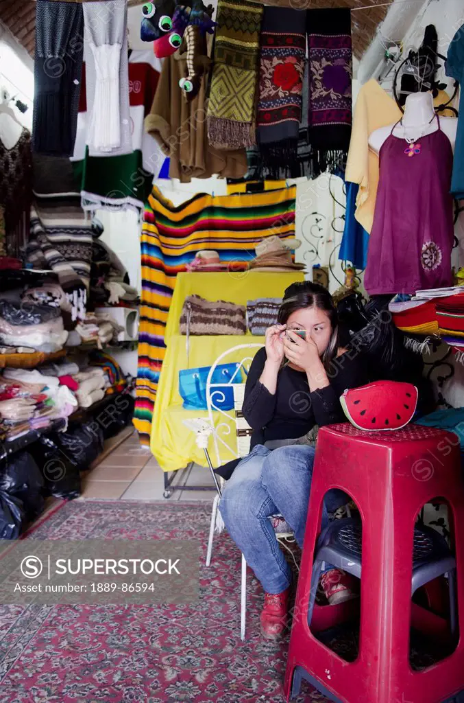 Mexico, Guanajuato State, Souvenir Vendor Applying Makeup In Her Shop; Guanajuato