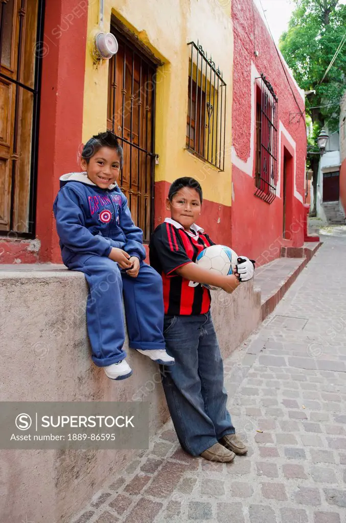 Mexico, Guanajuato State, Portrait Of Two Young Boys With Soccer Ball In Alley Of Old Spanish Town; Guanajuato