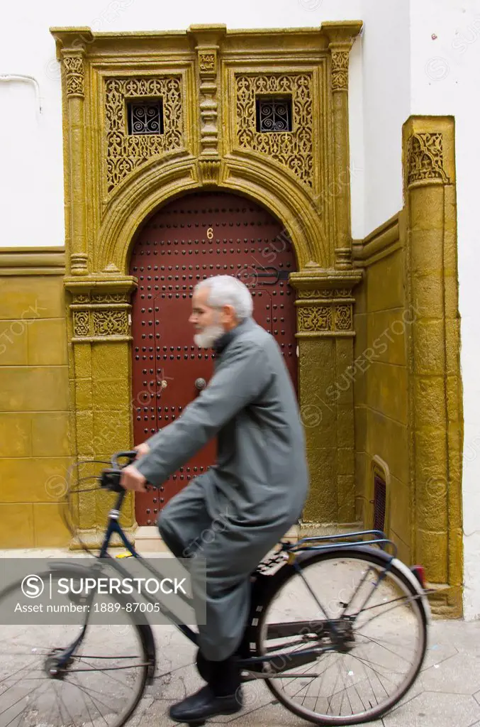 Morocco, Man Riding His Bike And Passing Ornate Entry To Building In Quartier Habbous; Casablanca